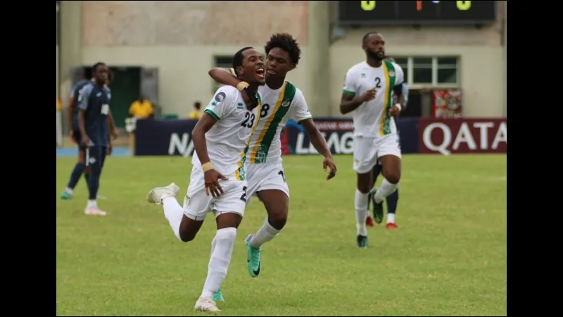 Cầu thủ Dominica và Sint Maarten tranh bóng trên sân cỏ Cầu thủ Dominica và Sint Maarten tranh bóng trên sân cỏ